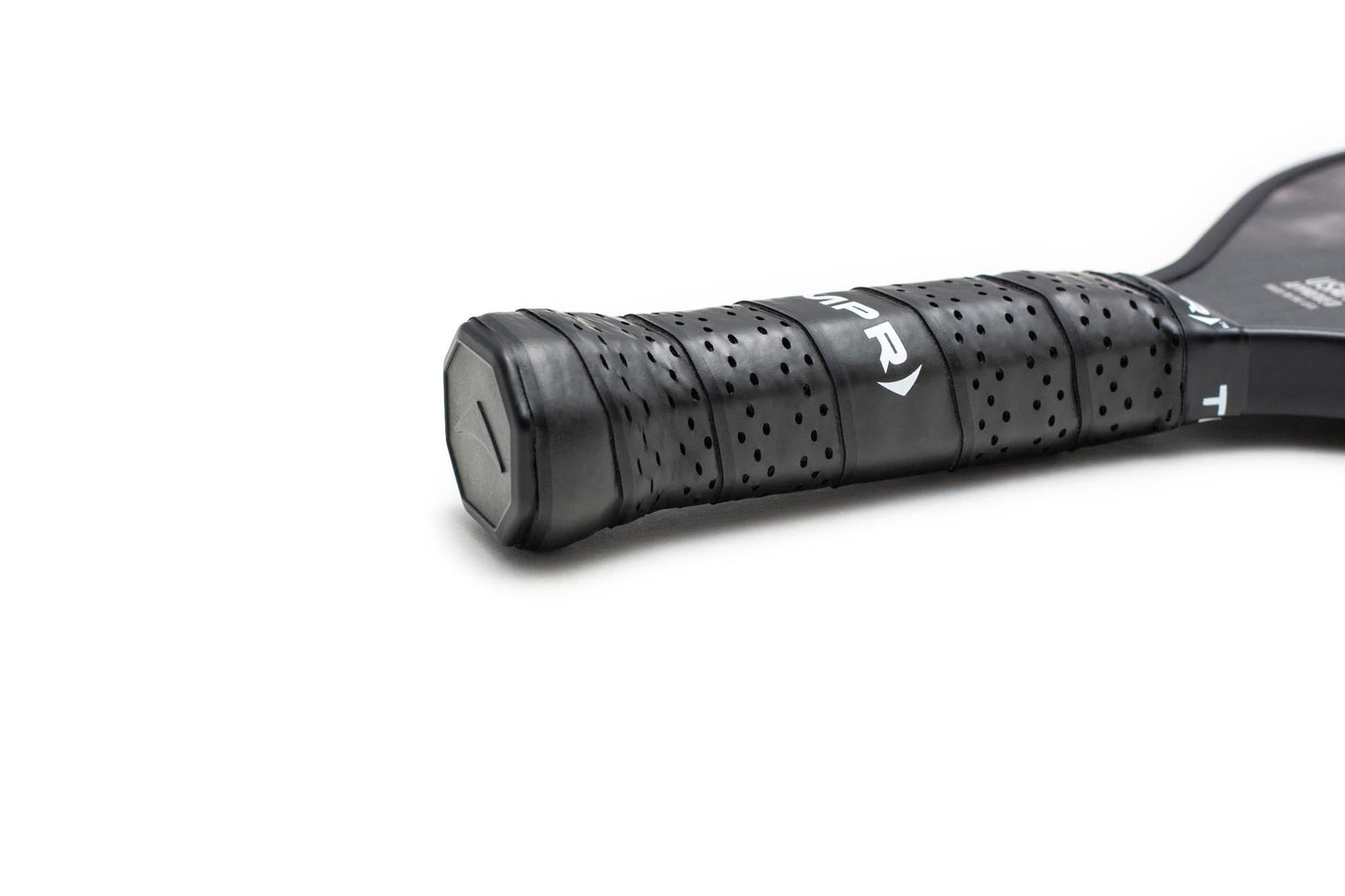 Close-up of the Ascend XT by TMPR Sports: its black handle is wrapped with perforated, textured grip tape for better vibration dampening. The black end cap stands out against a plain white background with the upper paddle blurred out.