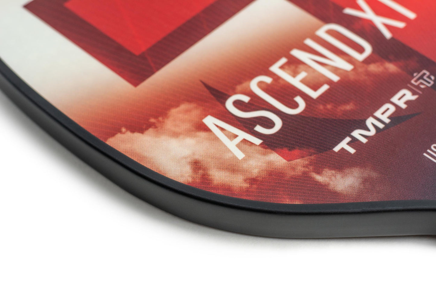 Close-up of the Ascend XT pickleball paddle by TMPR Sports, featuring a red and white cloud design, “ASCEND XT,” and the TMPR logo. The black edge suggests durability and advanced vibration dampening for power play.