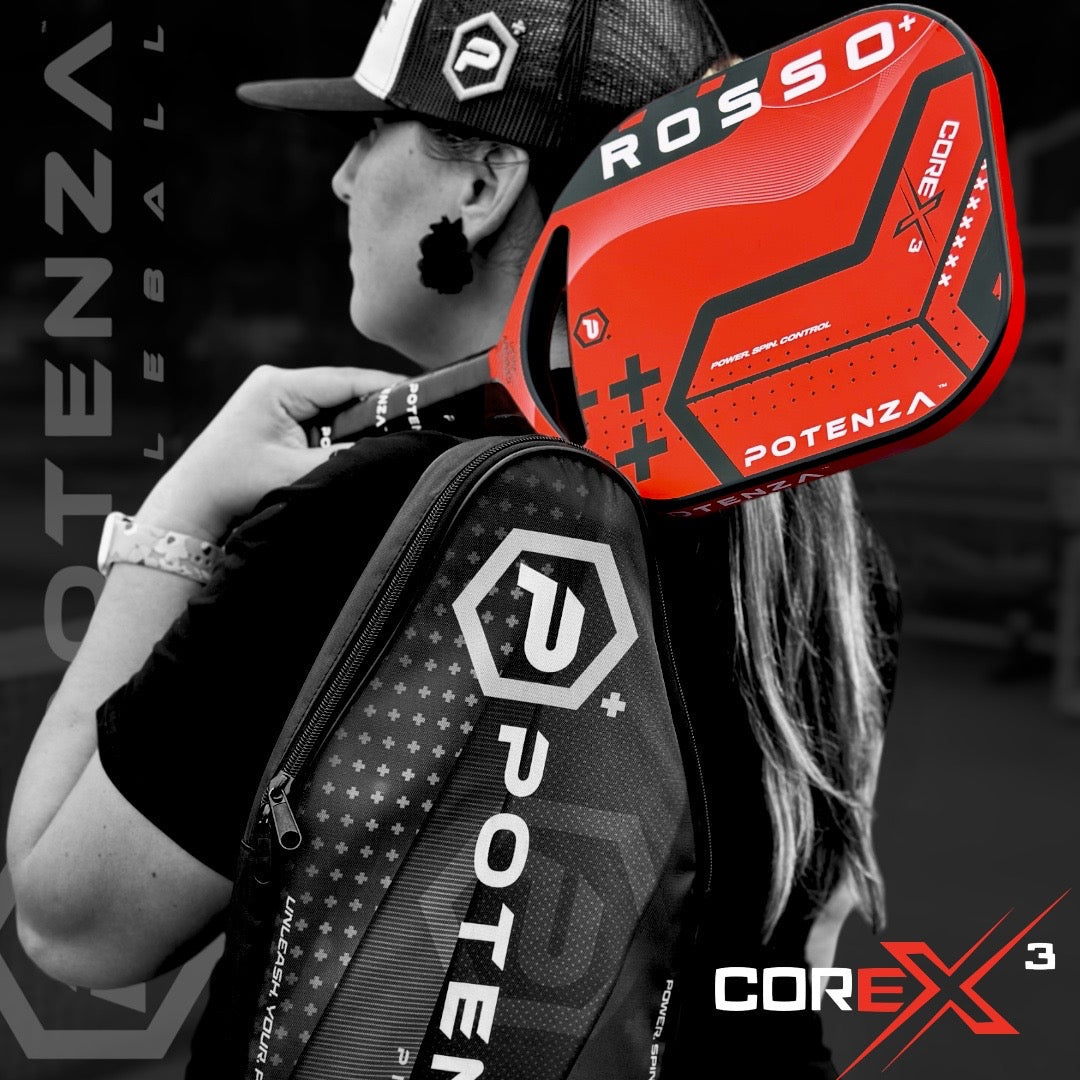 A woman in a cap and ponytail holds a vivid red Potenza Pickleball ROSSO+ COREx3 paddle and a black paddle bag with red and white details over her shoulder. The mostly black-and-white image highlights the products in bold color.