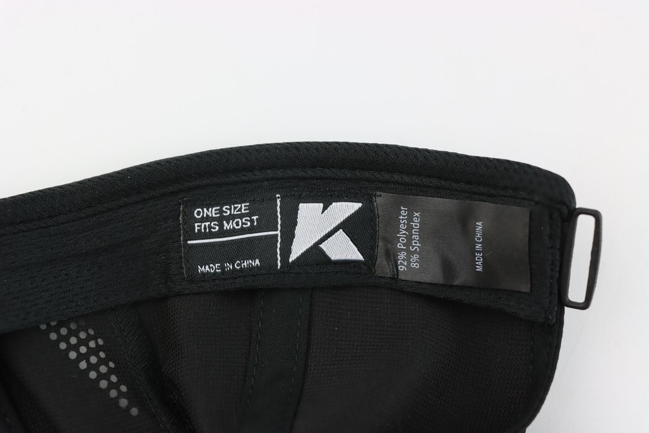 Close-up of the KONDOR PICKLEBALL Game Day Ready Quik Dry Hat's interior labels: one with a stylized "K" and size info, another noting the Quik-Dry technology blend. The athletic brim and adjustment strap are partially visible.