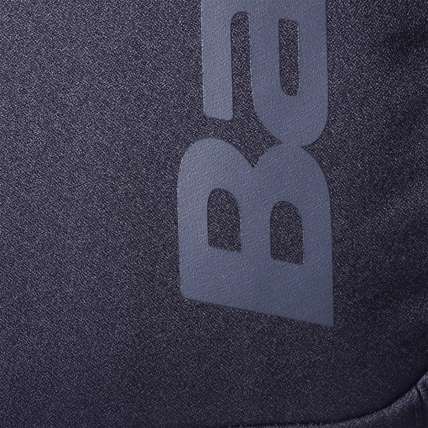 Close-up of the dark, slightly heathered fabric from the Babolat COURT Backpack LITE by Padel USA, featuring a soft texture and partial vertical “B” and “a” letters in light print—possibly made with recycled materials.