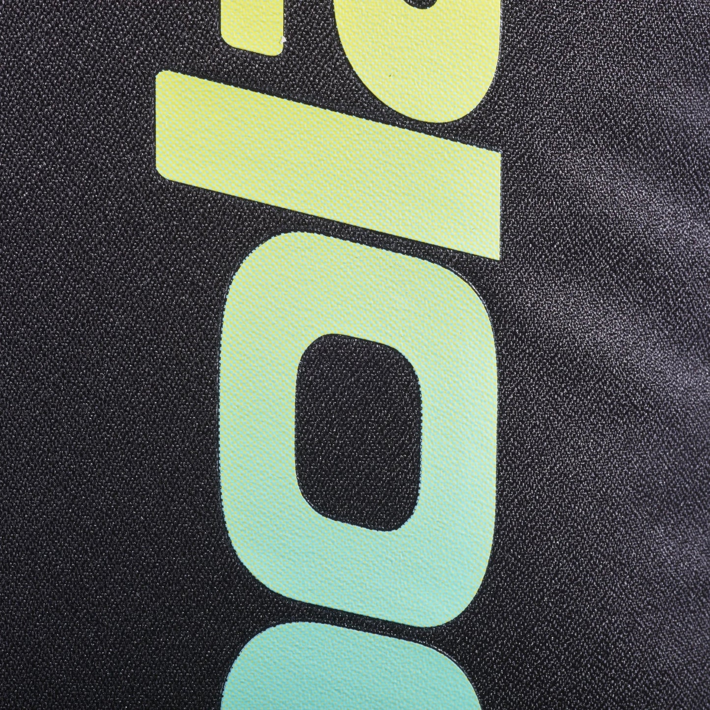 Close-up of the black textured fabric on the Babolat COURT Backpack LITE by Padel USA, featuring a bold “00” in a yellow-to-turquoise gradient. The detailed weave highlights recycled materials, blending sustainability with style.