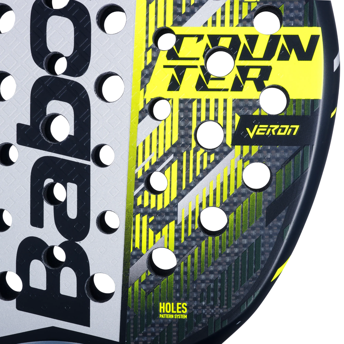 Close-up of the Babolat Counter Veron 2.5 padel racket by Padel USA, showcasing its black, grey, and yellow geometric face, Carbon-Fiberglass blend construction, and HOLES PATTERN SYSTEM among neatly arranged round holes.