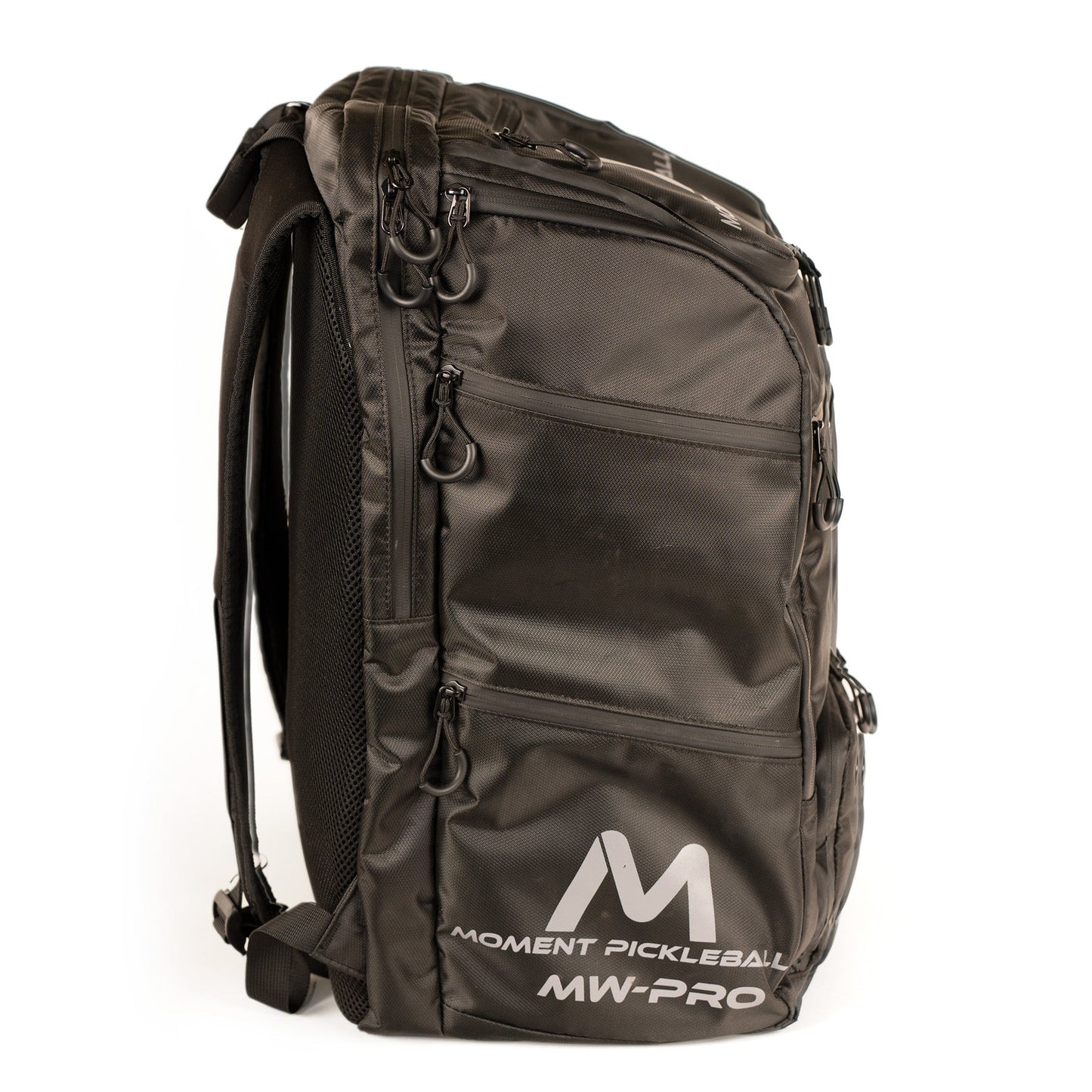 A black/silver Moment Pickleball MW-PRO Travel Bag stands upright, featuring zippered pockets for equipment, padded shoulder straps, a top handle, and the white MW-PRO logo on the lower front pocket.