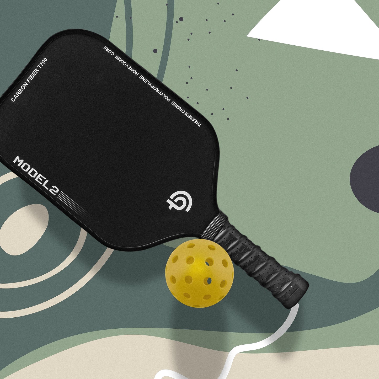 The Big Dink - Model2 Pickleball Paddle by The Big Dink, featuring a black carbon fiber face and textured grip, rests on a green and beige court with a yellow pickleball near the handle for enhanced spin and control.