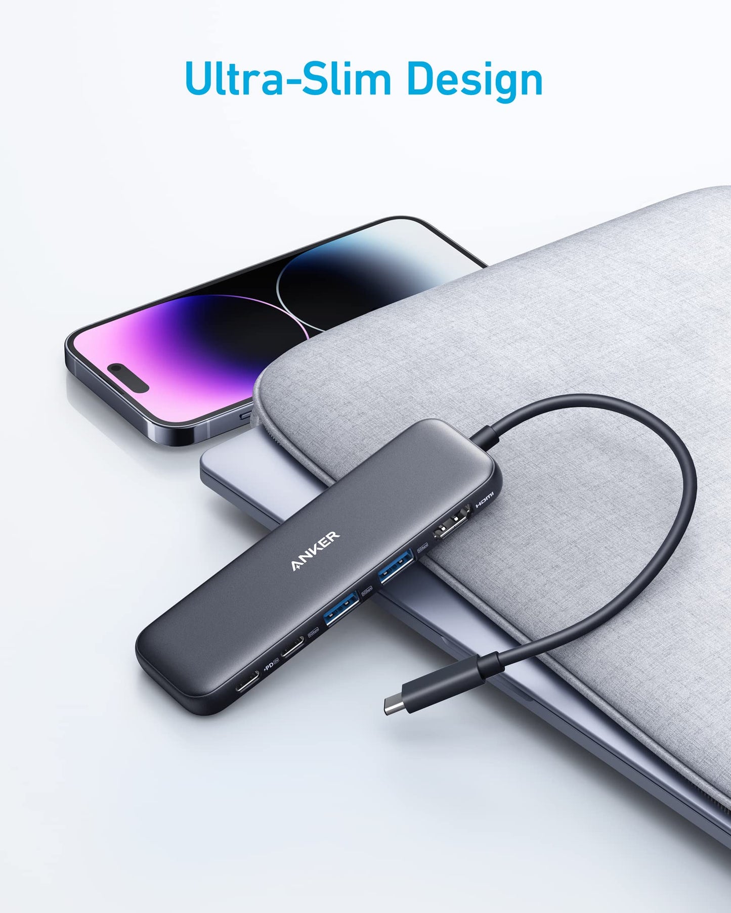 A refurbished Anker 332 USB-C Hub (5-in-1) sits on a closed gray laptop beside a modern smartphone, showcasing its multiple ports and ultra-slim design for versatile connectivity.