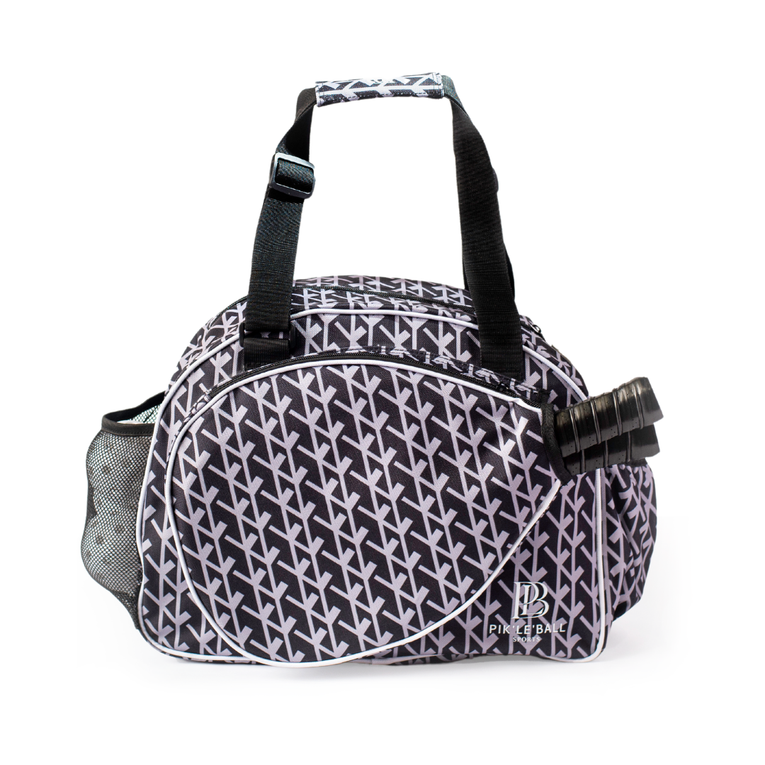 The Court Couture Premium Women's Pickleball Bag by Pik'le'Ball Sports features a chic black and white geometric design, sturdy handles, multiple compartments, mesh pocket, front zippered pocket for your water bottle, and a dedicated paddle sleeve.