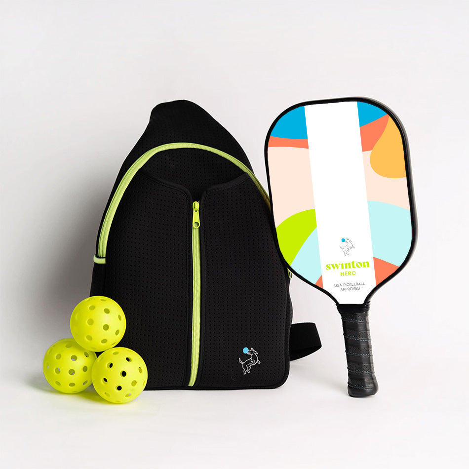 The Swinton Pickleball Starter Bundle - Black Sling Bag Combo includes a black backpack with neon yellow zippers, a white paddle with an abstract design, and three yellow pickleballs—a stylish gift for any pickleball fan.