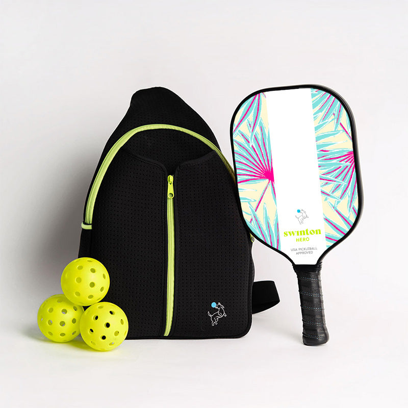 The Swinton Pickleball Starter Bundle - Black Sling Bag Combo includes a black bag with neon green trim, three yellow pickleballs, and a “swinton HERO” paddle featuring a teal, purple, and pink leaf design—an ideal pickleball gift.