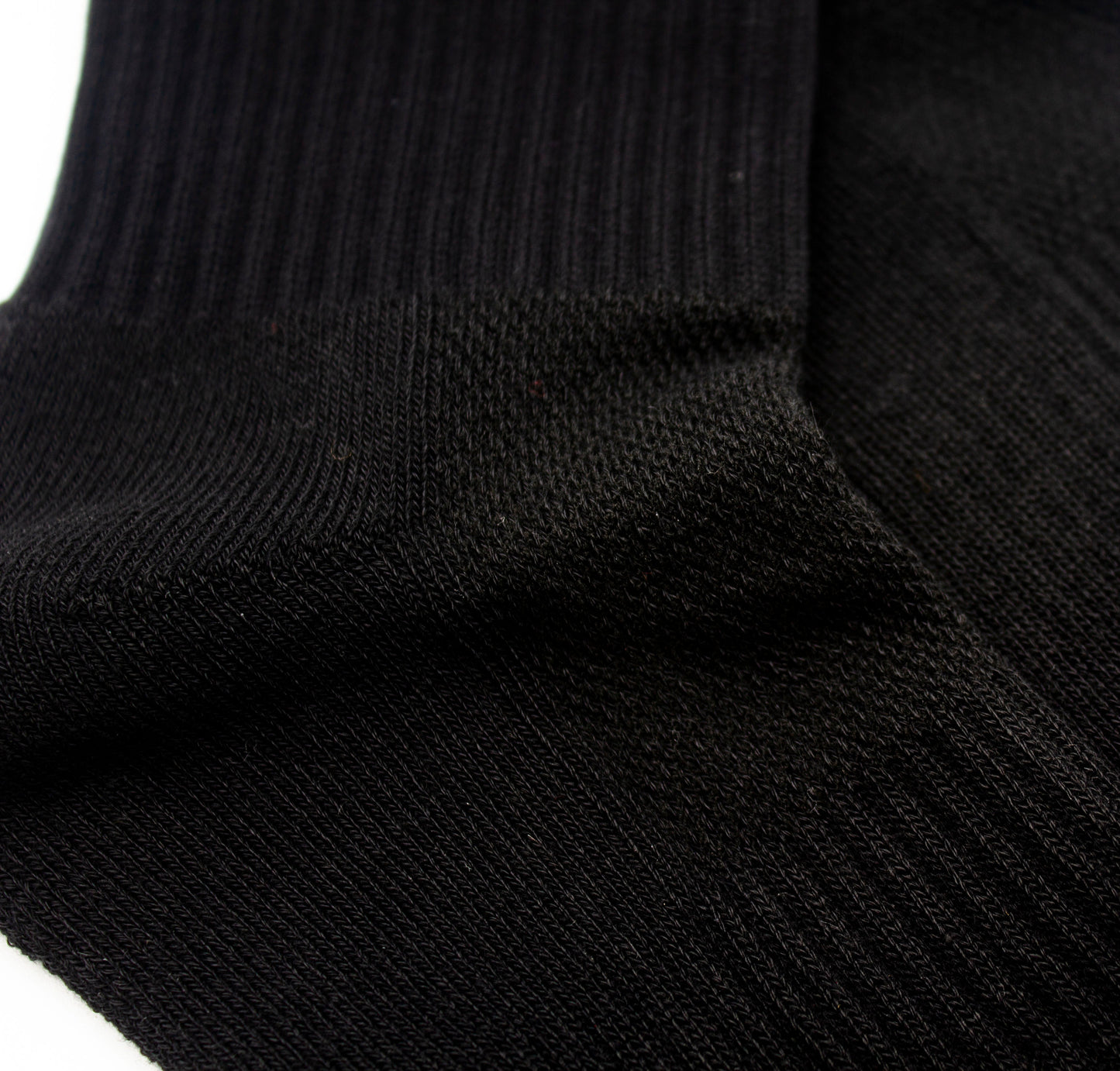 Close-up of Bodhi Performance's Performance Socks in black, featuring ribbed cuffs, fine knit texture, and subtle sheen. The breathable support and detailed weave are highlighted as the socks lay flat on a white background.