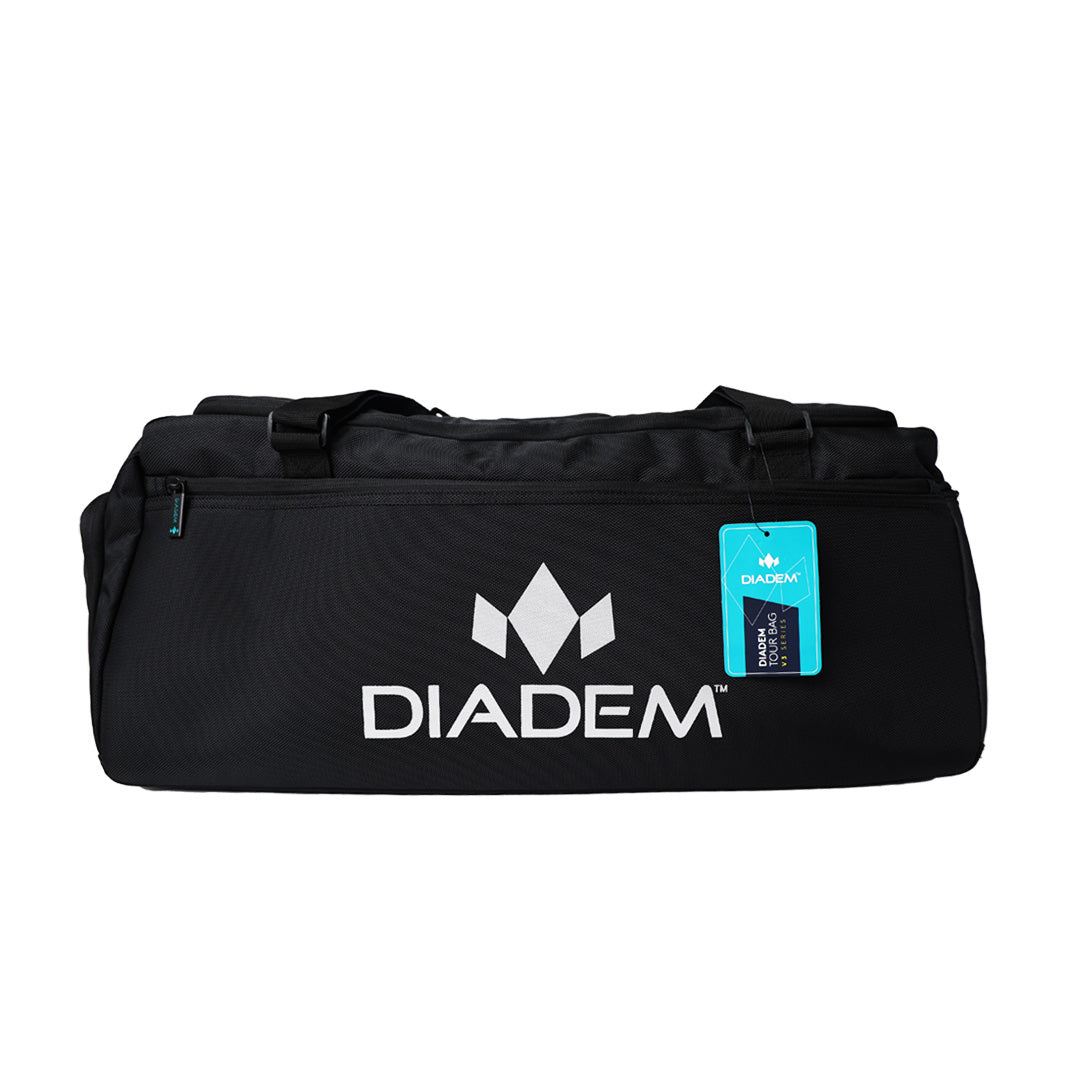 A black Diadem Sports Tour v3 Duffel Bag with the white Diadem logo and name printed on the side, featuring two top handles, a blue tag, visible zippers and seams, photographed against a white background.