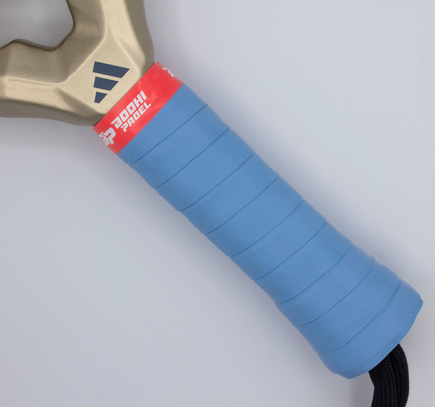 A close-up of the Bodhi Performance PROtack™ Premium Padel Overgrips shows a gold handle with a blue textured grip and red PROCTL PROGRIP band, featuring a dark blue three-stripe logo. Designed for excellent moisture absorption against a pale gray background.