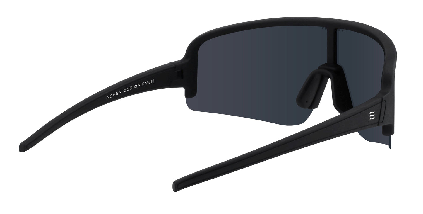 Neven Eyewear’s Threshold sunglasses feature a matte black wraparound frame, rectangular polarized UV400 lenses, straight arms, and “NEVER ODD OR EVEN” in white on the left. Padded nose pads are attached directly to the lens.