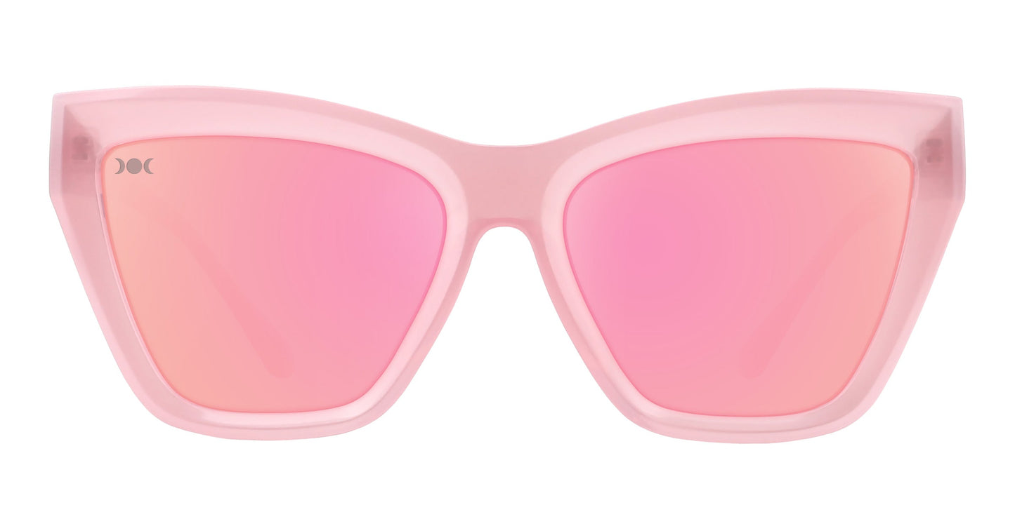 The Eclipse by Neven Eyewear are cat-eye sunglasses featuring a bold, transparent pink frame and large mirrored polarized lenses. These modern shades have a slight winged shape for added flair and standout style.