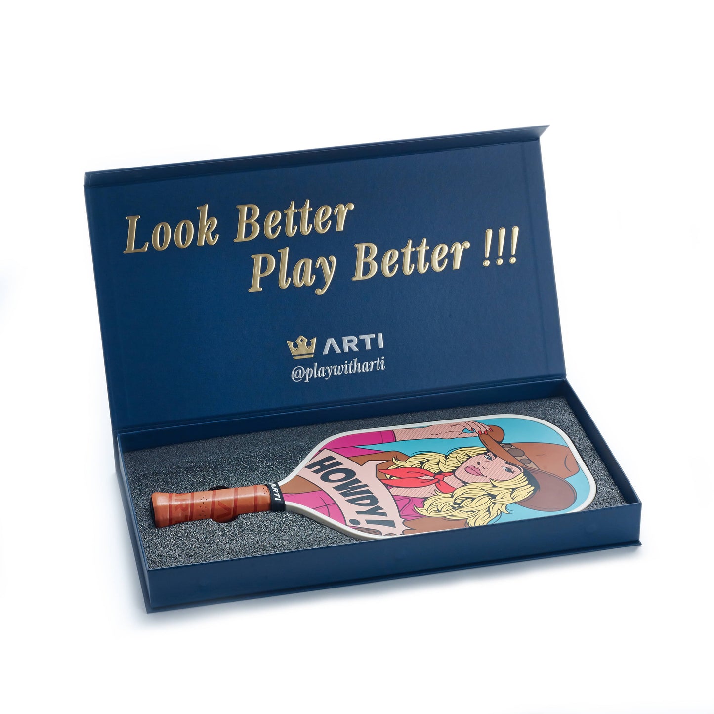 The ARTI Carbon Fiber Kristen & Kristy "HOWDY" Paddle features a cartoon blonde woman with a hat and "HOWDY!" speech bubble, in a blue box with gold “Look Better Play Better !!!” text. Includes the ARTI logo and USAPA approved tag.
