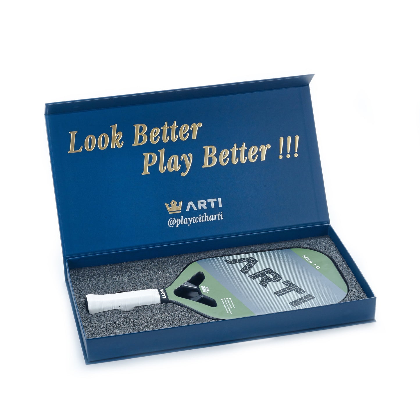 An open blue box presents the ARTI Carbon Fiber "MASTERY ELITE 1.0" paddle in green and gray, nestled in foam. Gold text inside the lid reads: Look Better Play Better !!! with the ARTI logo and @playwitharti beneath.