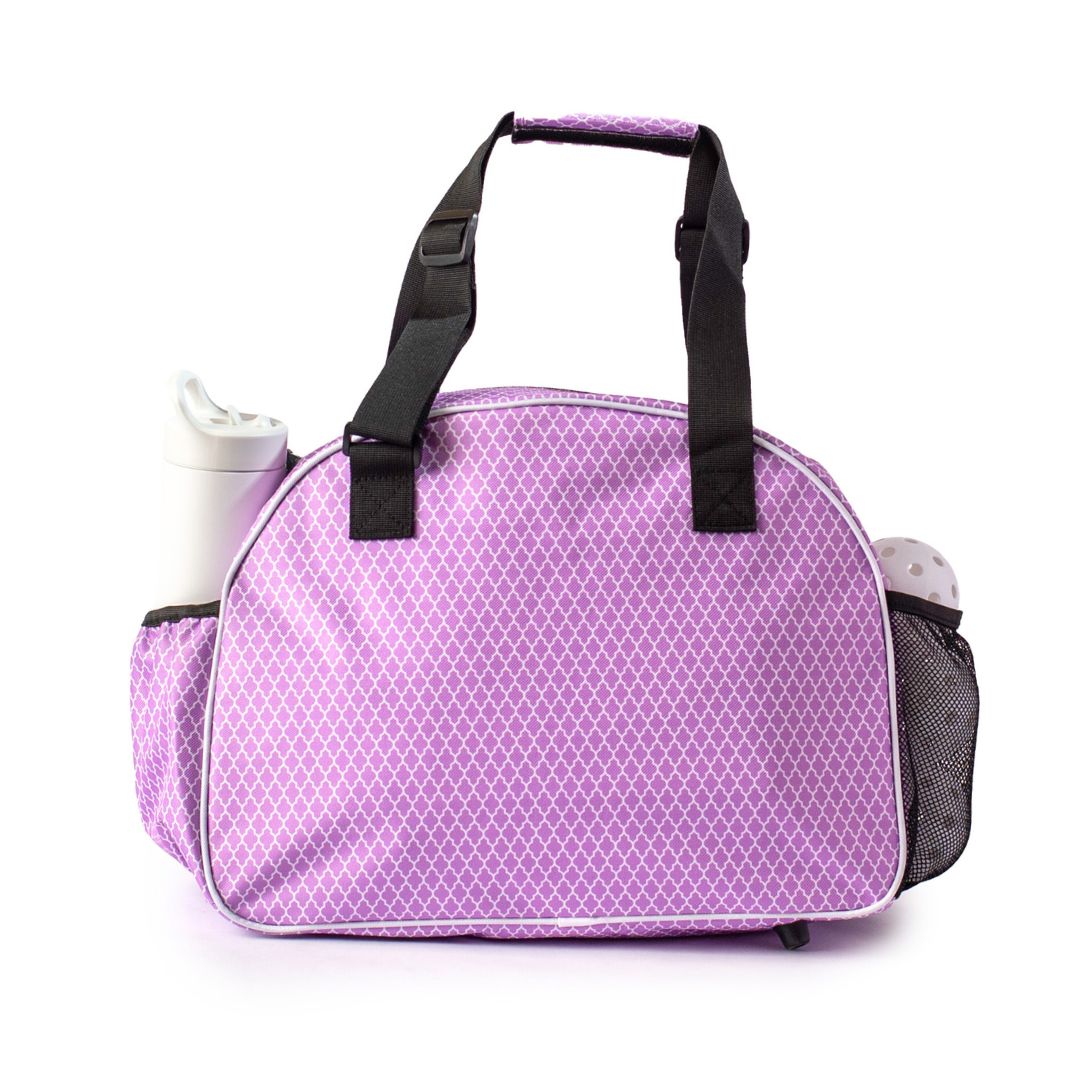 The Pik'le'Ball Sports Classy Premium Women's Pickleball Bag features a lavender and white geometric design, two black handles, and side pockets for bottles—combining fashion and function as the ultimate organizer for paddles and gear.