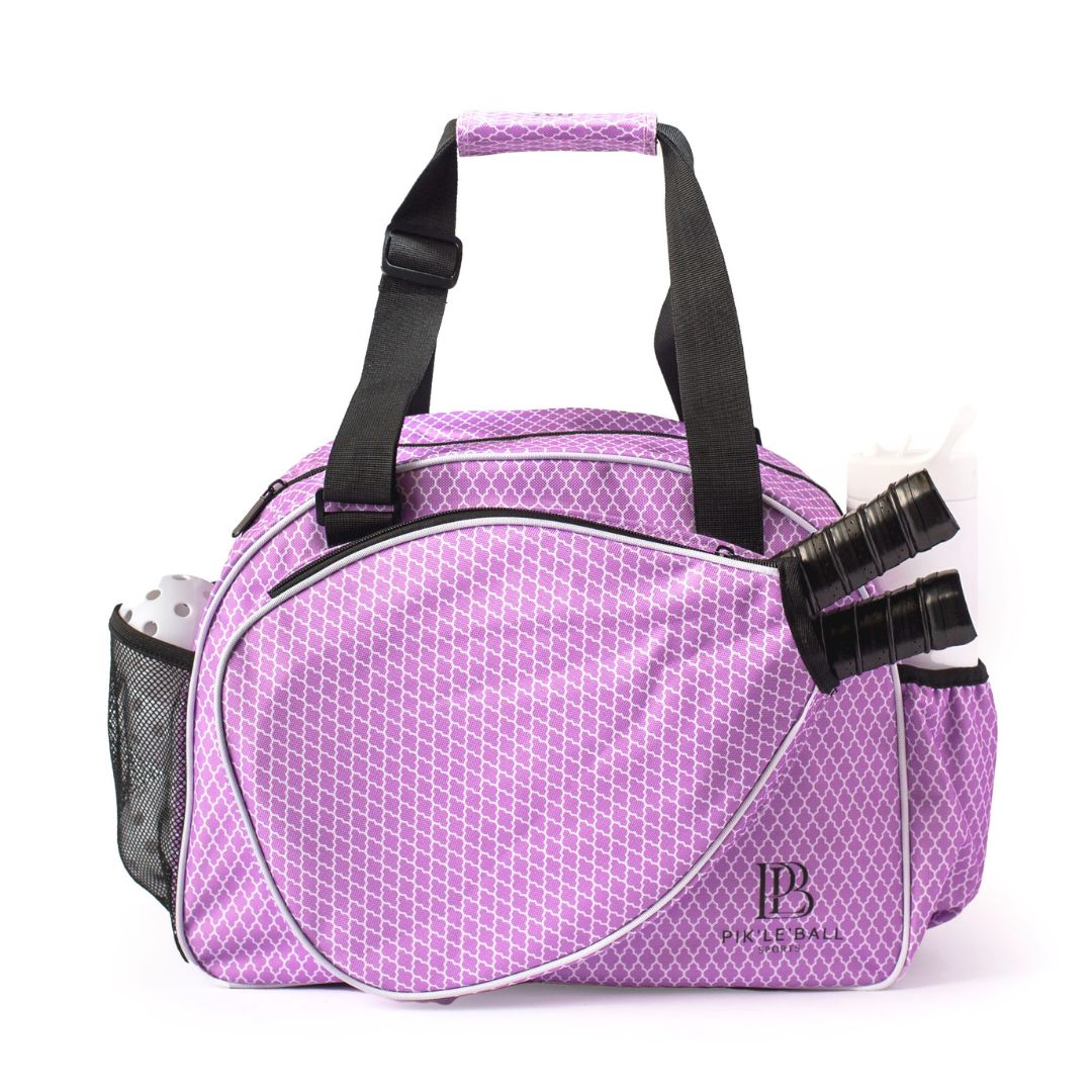 The Pik'le'Ball Sports Classy Orchid Premium Women's Pickleball Bag in purple has a white geometric pattern, black handles and trim, holds two rackets in the zip pocket, has a mesh side pocket for water, and "pp" is on the lower right corner.