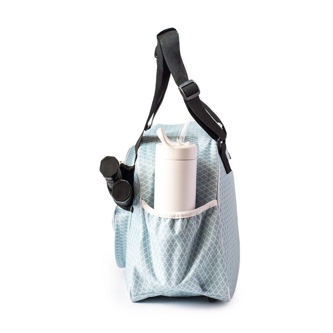 The Pik'le'Ball Sports Classy Sage Premium Women's Pickleball Bag is shown from the side. It features a black strap and an elastic side pocket holding a white water bottle with a straw and a black cylindrical item, set against a white background.