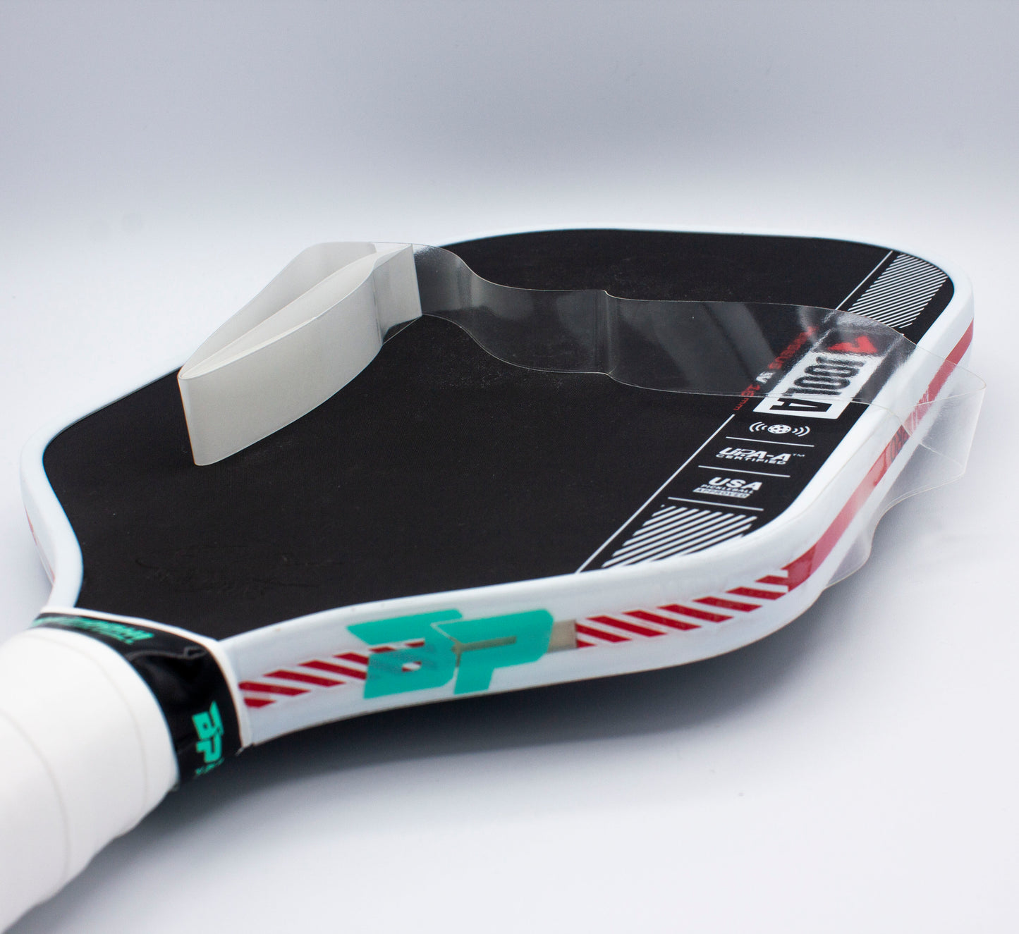 A black pickleball paddle with a white grip, green BP logo, red accents, and Bodhi Performance Premium Edge Tape - CLEAR for protection. A white overgrip tape sits on top, all against a plain white background.