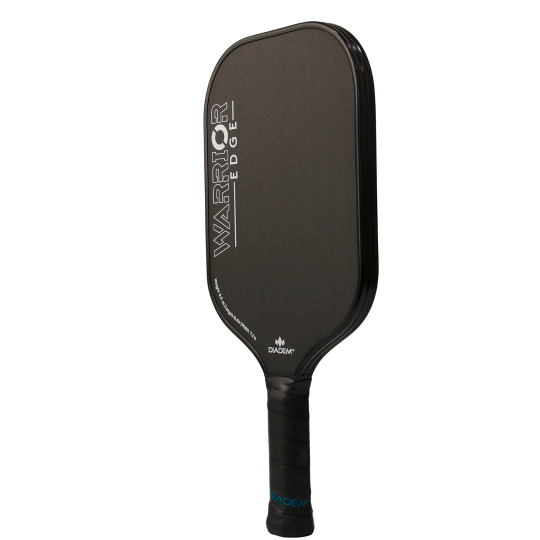 A black Diadem Sports Warrior Edge pickleball paddle with a rectangular etched carbon face, bold white lettering, and matte finish. Features black grip tape, DADEAM logo near the throat, and is USAPA approved for official play.