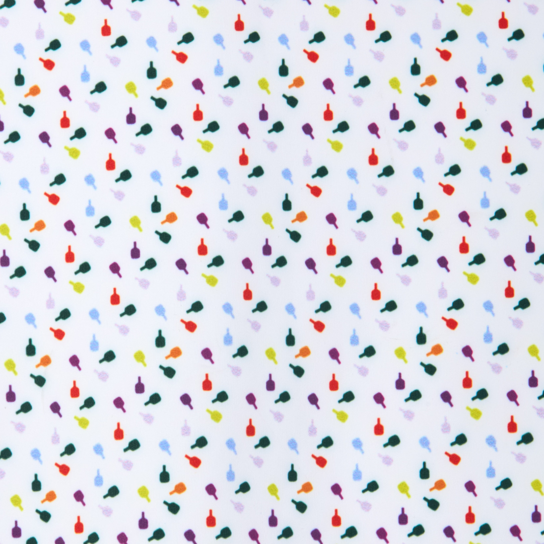 The Sammy Skort 2.0 by Playly Store features a white background with evenly scattered, colorful bird and bottle silhouettes in red, orange, yellow, green, blue, and purple hues inspired by court fashion.