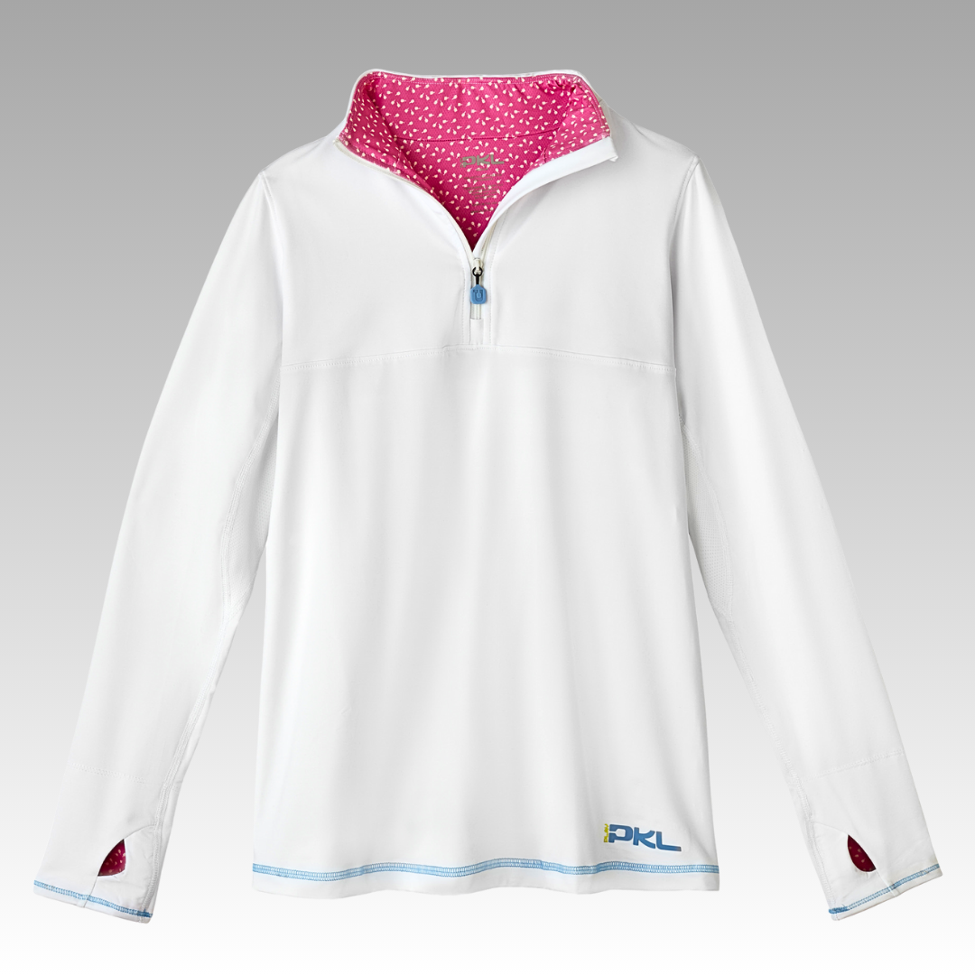 The Soleil Tech Shirt by Playly Store is a long sleeve top with a half-zip front, thumb holes, pink polka dot lining, light blue stitching, and "PKL" embroidered in blue and yellow near the hem. Made from breathable fabric.