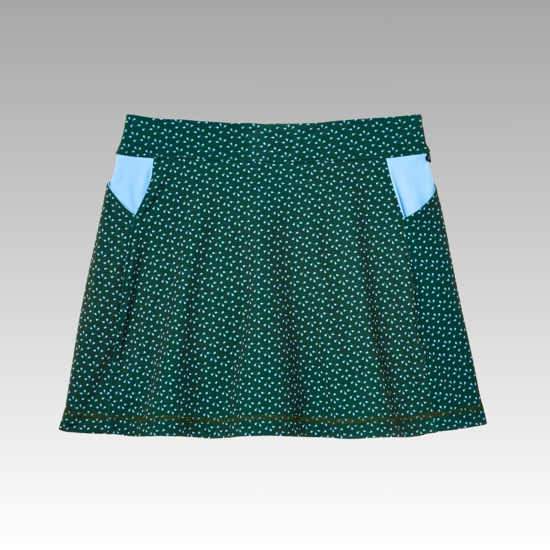 The Playly Store Sammy Skort 2.0 is a dark green, flared pickleball skort with white polka dots, two light blue triangular side pockets, and CoolFlow fabric, shown on a gradient gray background.