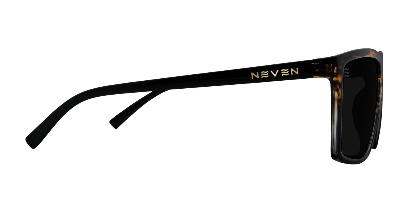 Side view of Neven Eyewear’s Asbury sunglasses shows black frames with tortoiseshell detail by the hinge, gold Neven branding, and dark polarized UV400 lenses. The rectangular style has slightly curved arms for extra comfort.