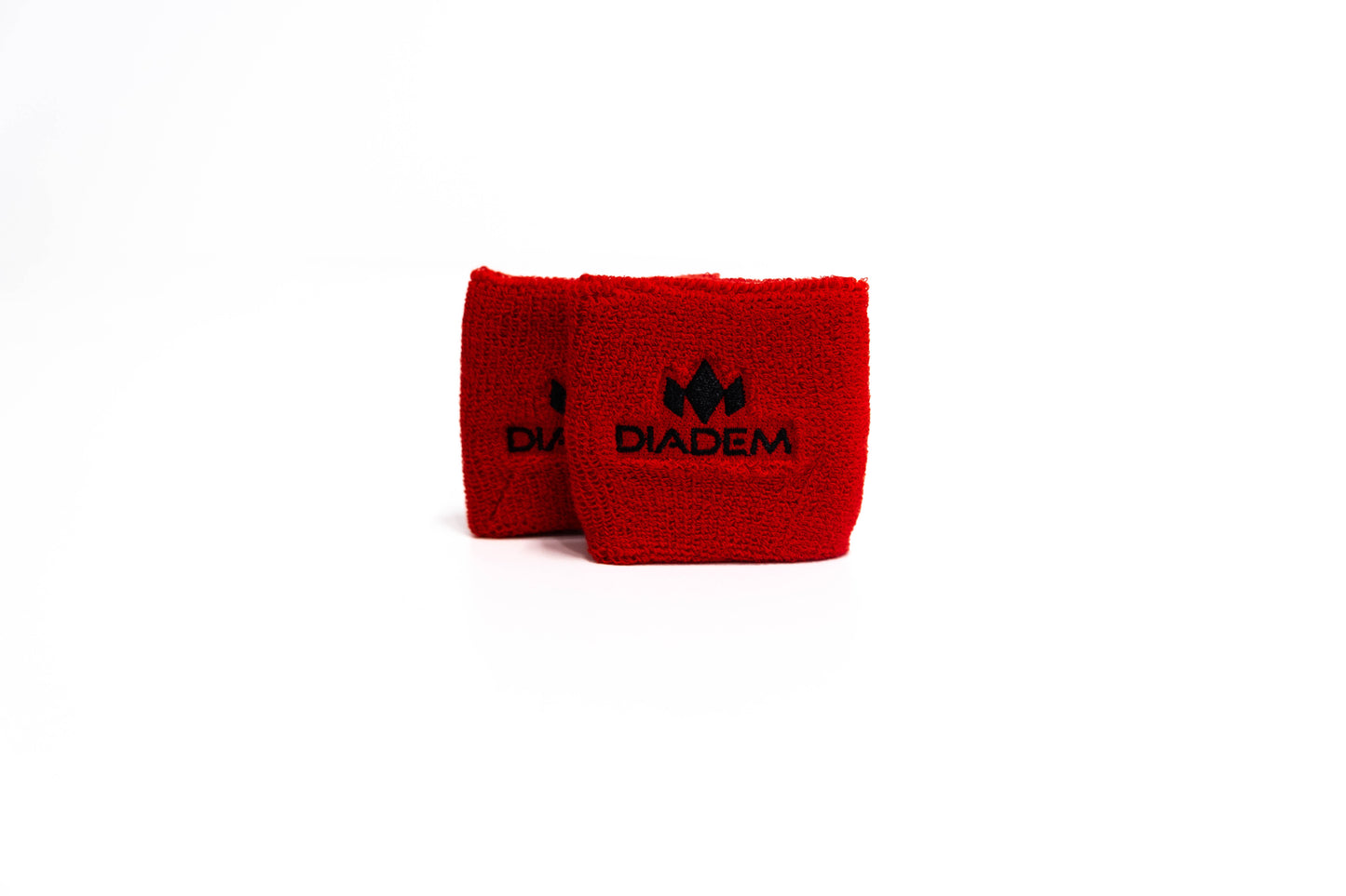 Two red Diadem Sports Logo Small Wristbands, made of soft, textured fabric, are displayed side by side on a white background. Each features the Diadem logo and "DIADEM" centered on the front.