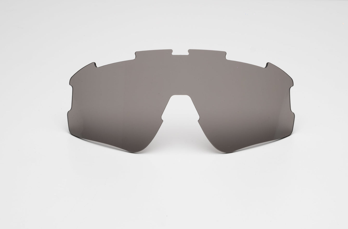 A Thrive Pickleball Additional Lens Color in dark-tinted gray sits on a white background. Designed with cutouts and angular edges for a wraparound frame, it offers UV protection. No frame or arms are included.