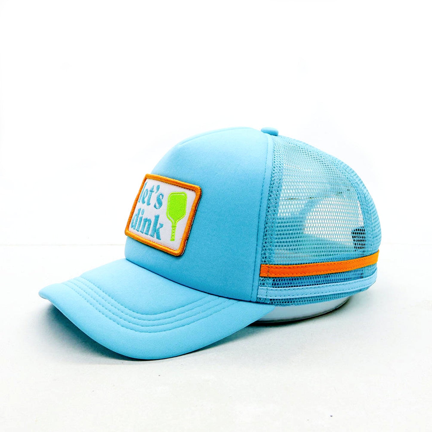 The Swinton Pickleball Dinking Cap Foam Snapback Hat features a light blue breathable mesh, orange trim, a curved brim, and an adjustable snap closure. An orange-and-white "lets drink" patch with a green cup icon is embroidered on the front. Plain white background.