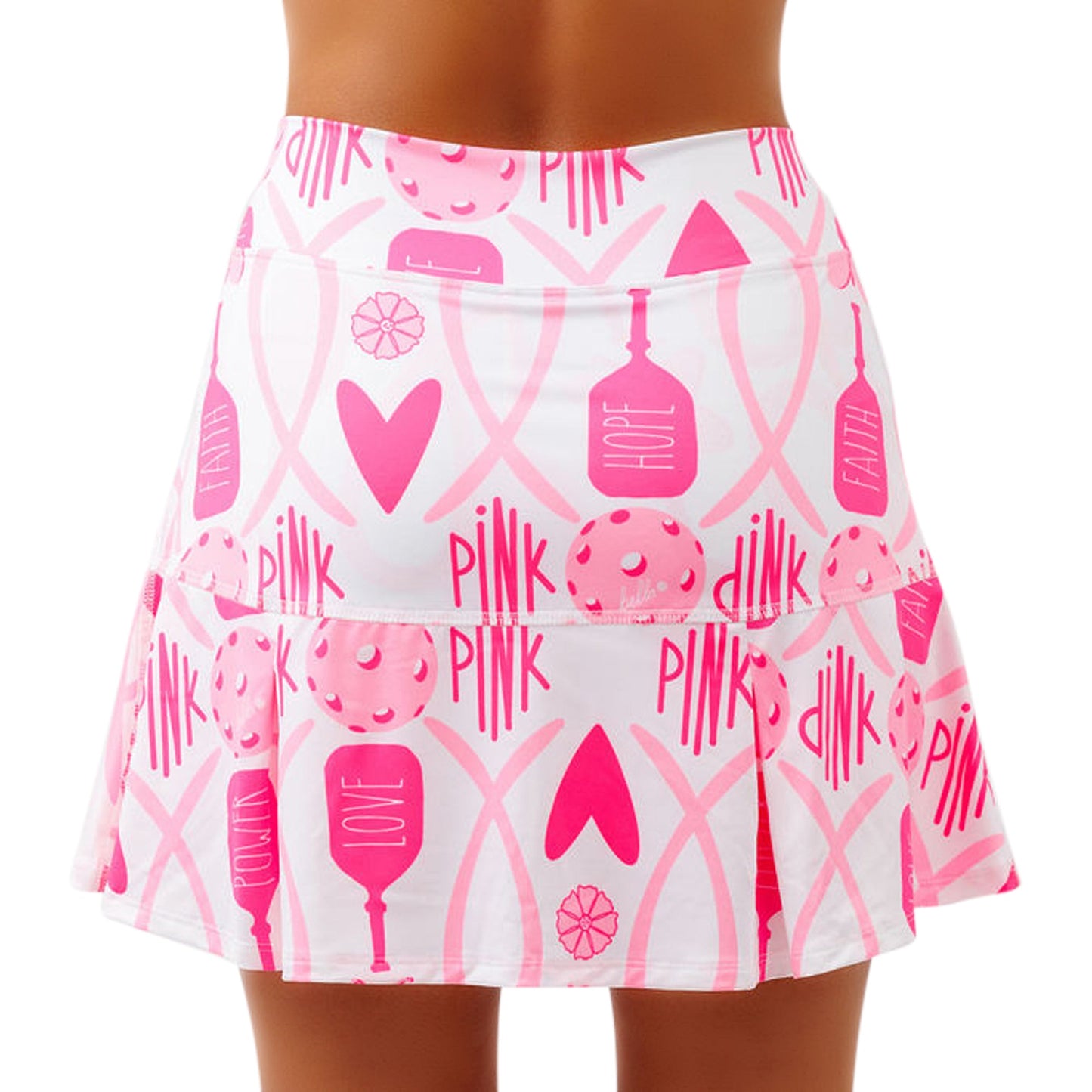 A close-up of a woman’s lower back showcases the Pickleball Bella PB Drop Pleat Skort Hope, a white skirt with built-in compression shorts and flared hem adorned with pink PINK, LOVE, HOPE, FAITH text, hearts, and donuts for breast cancer awareness.