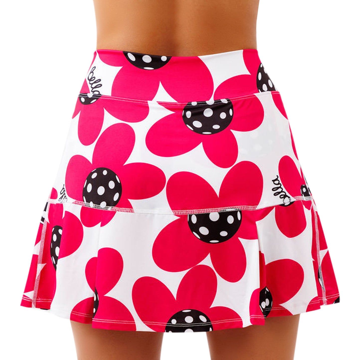 A person wears the Pickleball Bella PB Drop Pleat Skort Poppy, a figure-flattering skort with a no-roll waistband and bold red flowers with black and white polka dot centers. Slightly flared, it fits snugly at the waist for style and comfort.