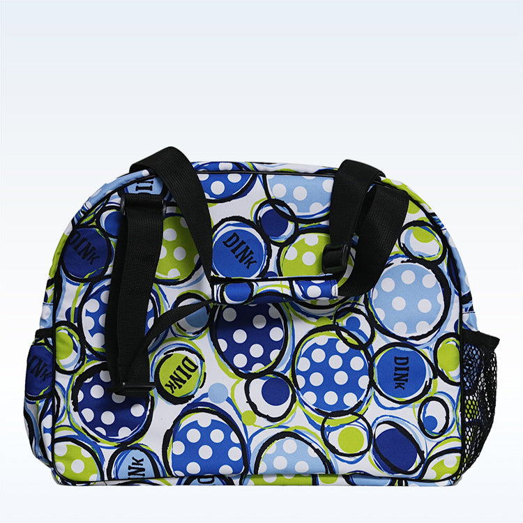 The Pickleball Bella PB Duffle Bag Dink 1 features a blue, green, and white polka-dot design with “DINK” circles, black handles, a zippered paddle pocket, and mesh side pocket—perfect for pickleball gear.