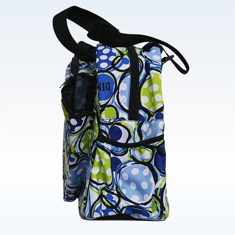 Side view of the Pickleball Bella PB Duffle Bag Dink 1, featuring a bold blue, green, and white abstract pattern. Includes two zippered compartments, an outer paddle pocket, black handles, and a light gradient background.