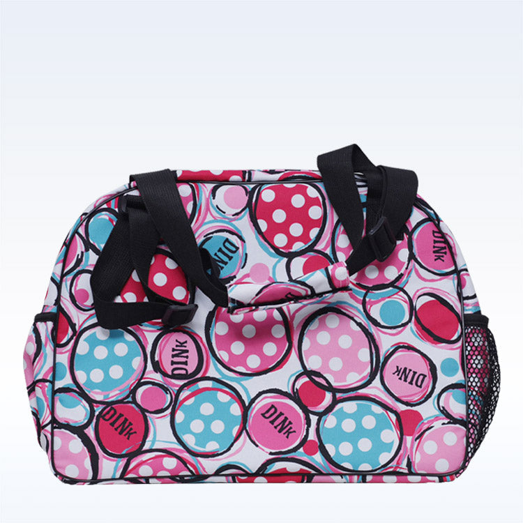 The Pickleball Bella c duffle bag has black straps, a vibrant pink, blue, and white overlapping circle pattern, a side mesh pocket for gear, and a zippered paddle pocket on a light gradient background.
