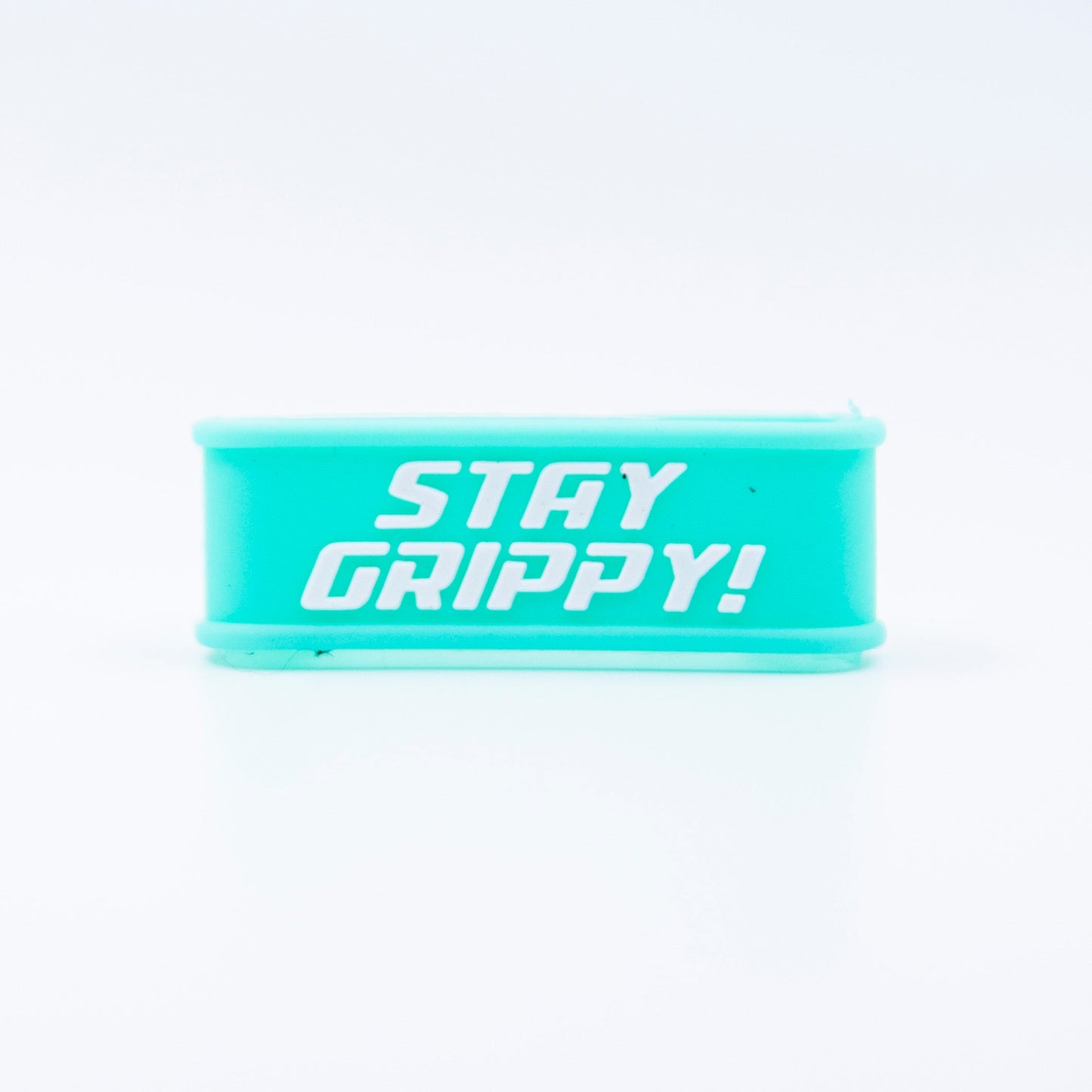 The Bodhi Performance Paddle Bands are teal silicone wristbands with bold white "STAY GRIPPY!" text centered on them, perfect as pickleball paddle grip bands. They have a clean, shiny finish and smooth edges, shown against a plain background.