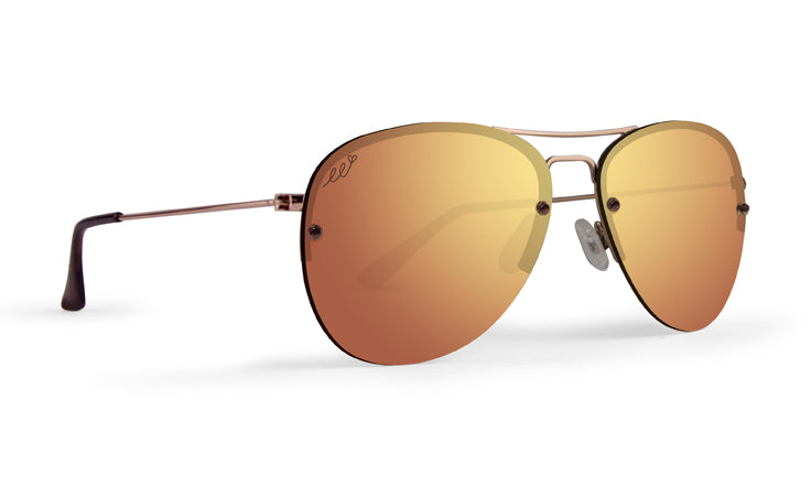 The Emerson by Epoch Eyewear are aviator sunglasses with thin metallic frames, orange-gold mirrored UV lenses, clear nose pads, black-tipped slender arms, and a subtle decorative mark on the upper left lens.