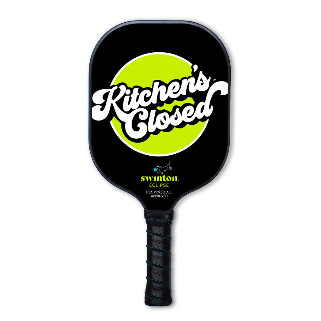 The Swinton Pickleball Eclipse Kitchen's Closed paddle features a textured graphite black face, a bright green center circle with “Kitchen’s Closed” in bold white script, yellow branding, and a textured black grip handle.