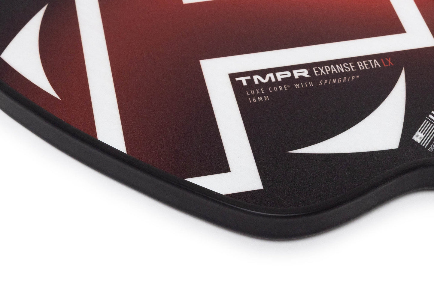 Close-up of the TMPR Sports Expanse Beta LX hybrid pickleball paddle. Its red and white fiberglass face showcases bold geometric patterns, branding, and a black edge guard for enhanced power and spin.