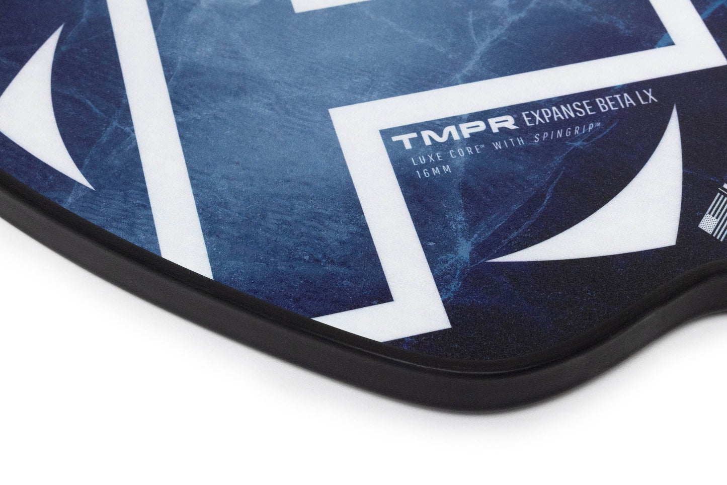 Close-up of a TMPR Sports Expanse Beta LX | Indigo Ice paddle in blue and white with bold geometric designs, black edge guard, and SpinGr8 16mm for superior spin. TMPR Sports branding is printed on the face.