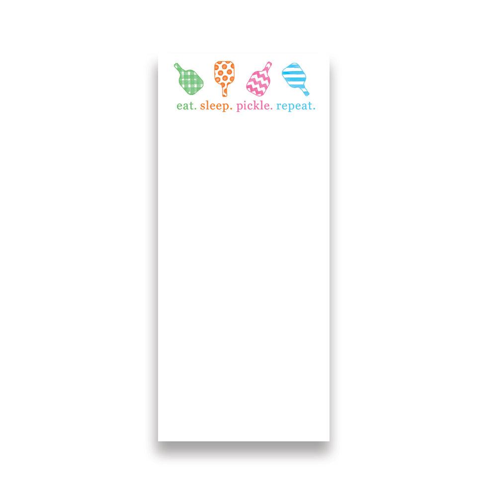 The Fresh Pickle Pickleball List Notepad features four colorful paddles and “eat. sleep. pickle. repeat.” Perfect for any pickleball lover, this notepad offers plenty of blank space for notes or reminders—great as a fun gift!.