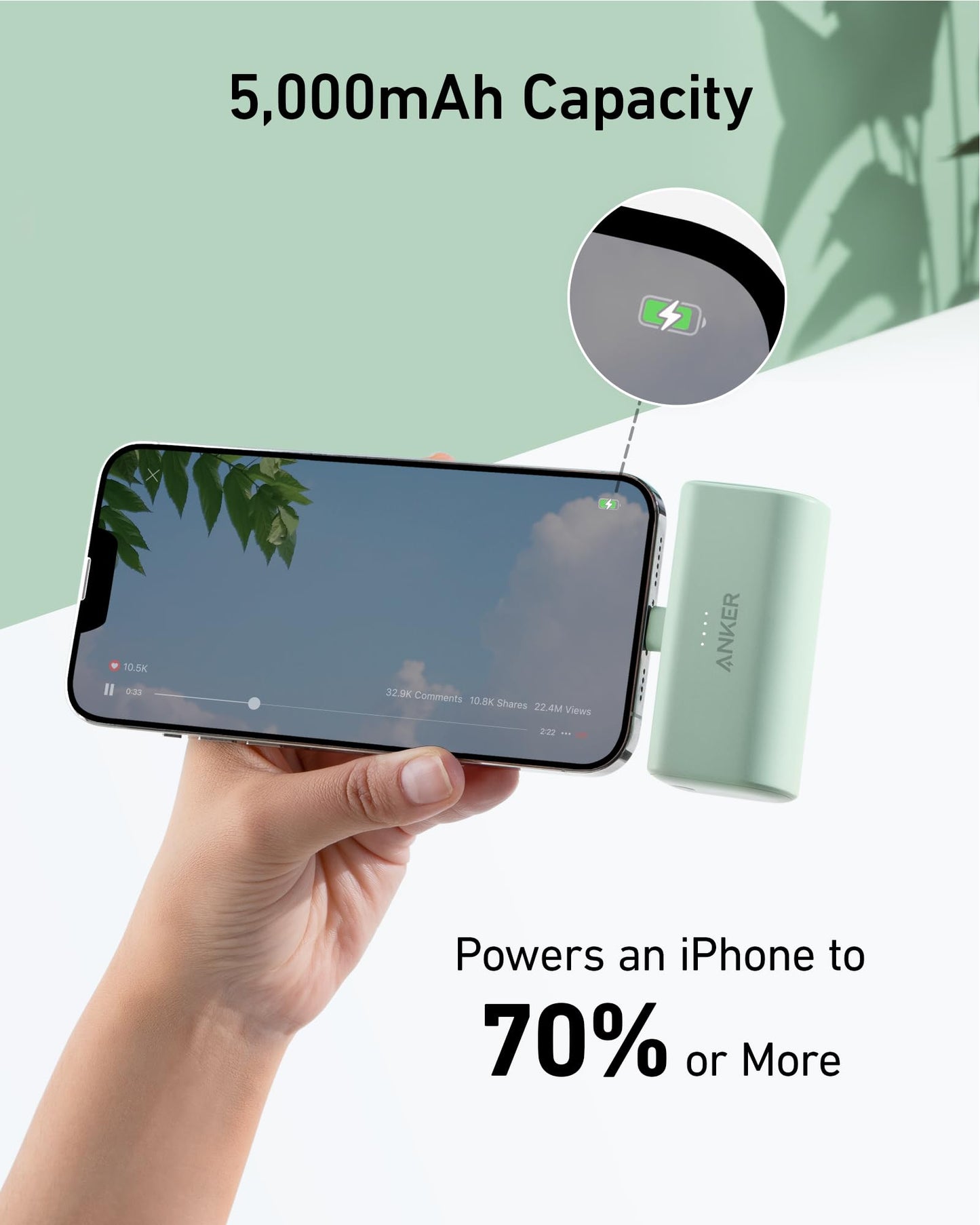 A hand holds an iPhone charging with the Anker Nano Power Bank (12W, Built-In Lightning Connector). The screen displays a video with tree reflections. Text highlights 5,000mAh capacity and powers an iPhone to 70% or more, plus a close-up of the charging icon.