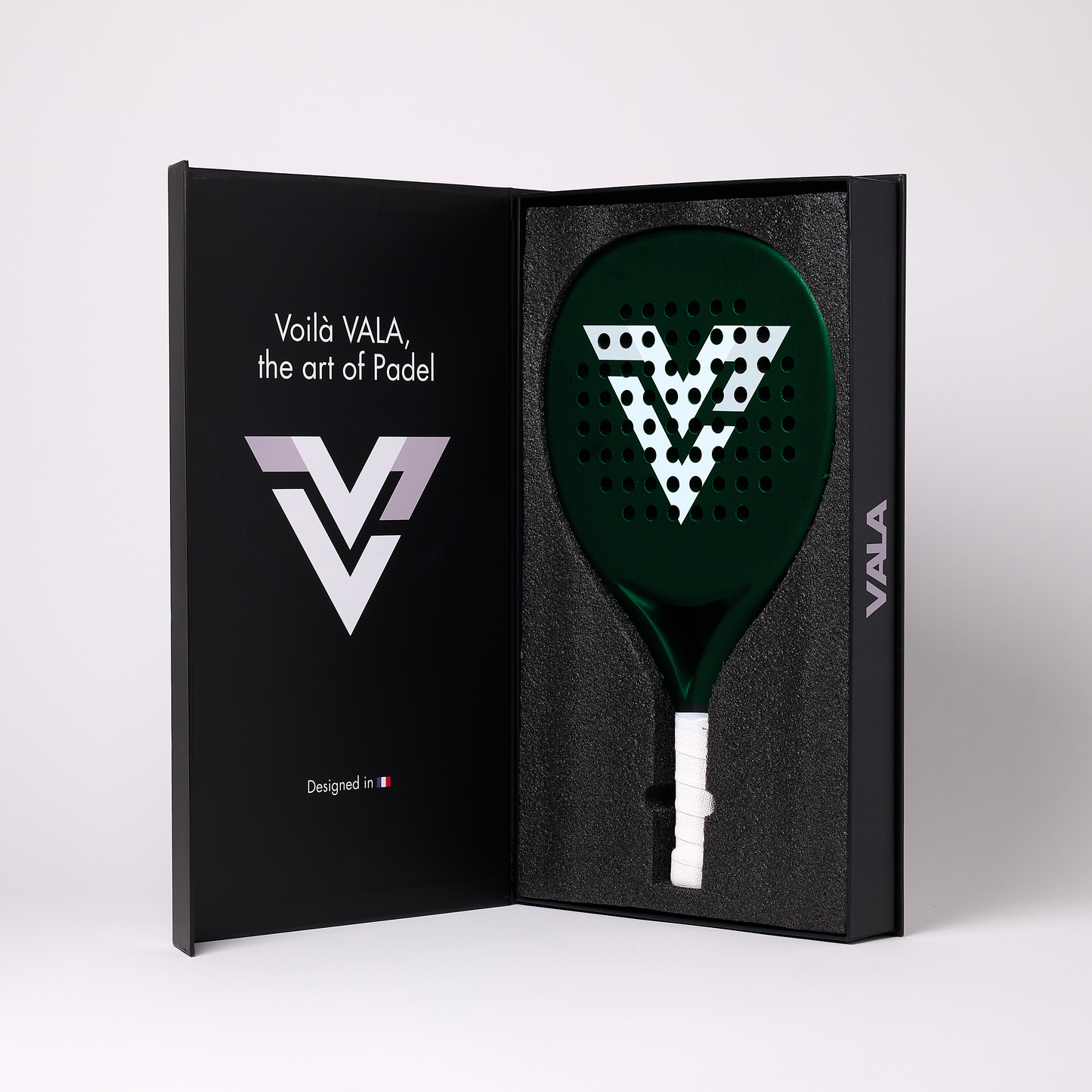 The VALA One (Green Edition) by VALA comes in a black box with “Voilà VALA, the art of Padel,” a stylized V logo, and French flag inside. The green padel racquet has a large white V logo, white grip, and EVA foam core for control.