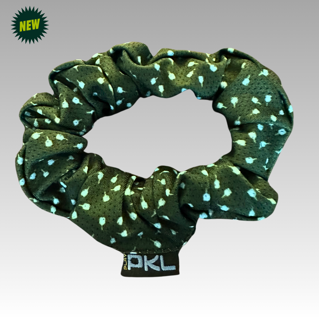 The Shanti Pickleball Hair Scrunchie by Playly Store, dark green with light blue and white dots, is shown on a gradient gray background. A black PKL tag is attached, and a green "NEW" badge appears in the top left corner.