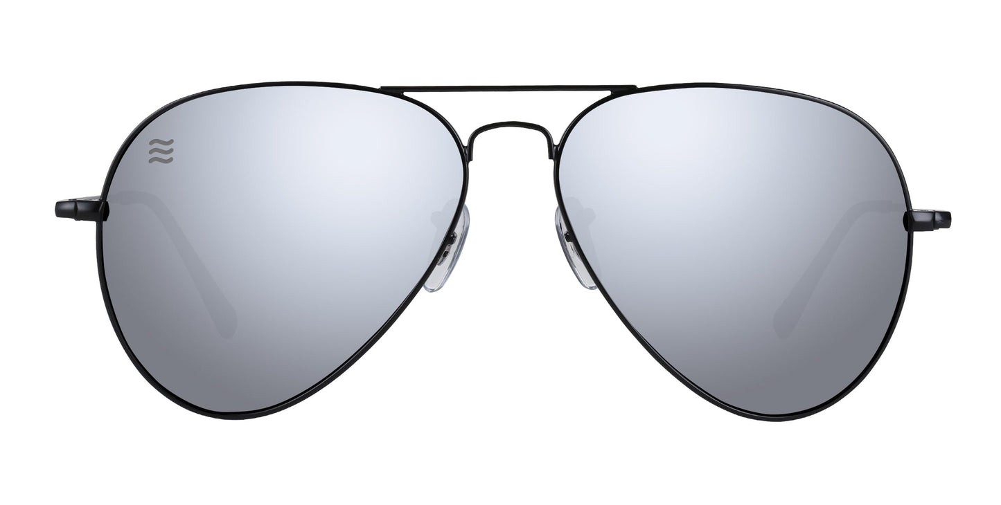 Neven Eyewear’s Mavs sunglasses feature thin black stainless steel frames, large polarized UV400 silver lenses, clear nose pads, and a small wave logo on the upper left lens. Displayed on a plain white background.
