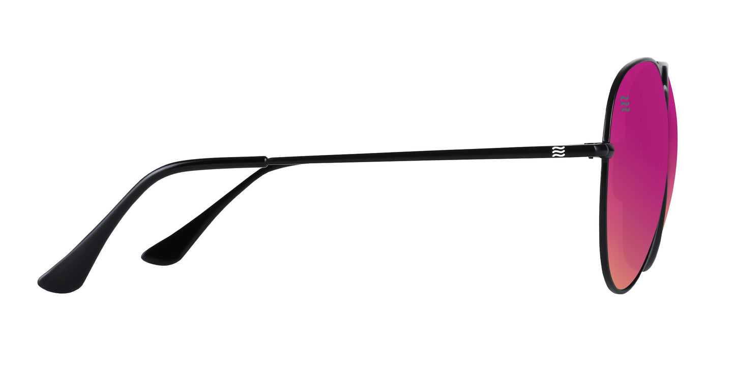 A side view of Neven Eyewear’s Space Coast sunglasses shows black frames with vibrant pink-red mirrored polarized lenses. The thin stainless steel arm, with a small silver logo near the hinge, curves downward against a white background.