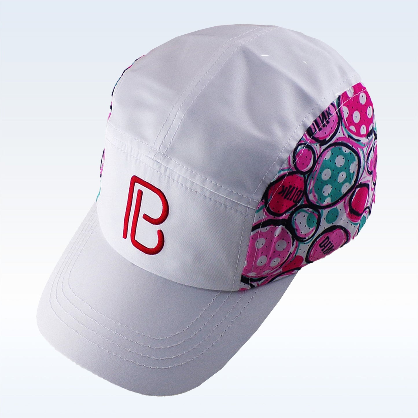 The Pickleball Bella PB Cap Dink 2 is a white cap with curved brim, stitched panels, and breathable mesh. Colorful pink, teal, and purple circles with text decorate the sides. The front features a red PB logo on light blue; adjustable velcro for comfort.