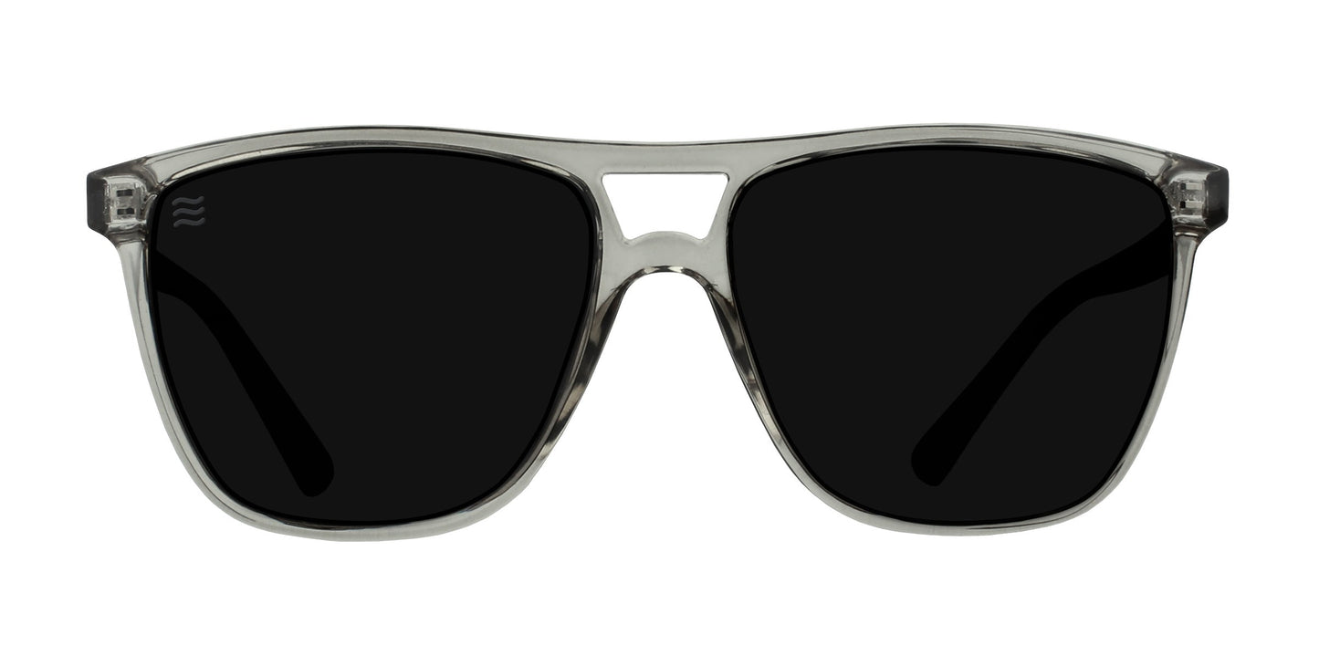 The Rip Tide by Neven Eyewear are modern, sleek polarized sunglasses with large dark lenses, a transparent gray frame, squared keyhole bridge, and UV400 protection—perfect for sunny days at Indian Harbor Beach.